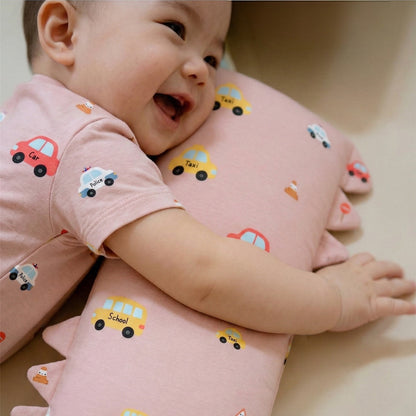 baby wearing bamboo short rompers in dusty pink colour with a bamboo pillow with vehicle design. looking very comfortable on it. cuteboid brand