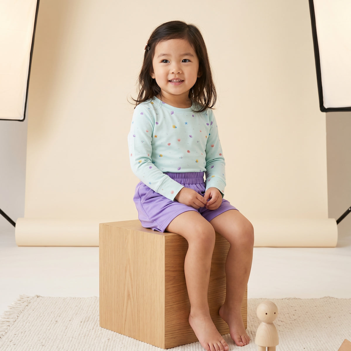 kids sitting on a wooden block wearing bamboo t shirt with seashell prints